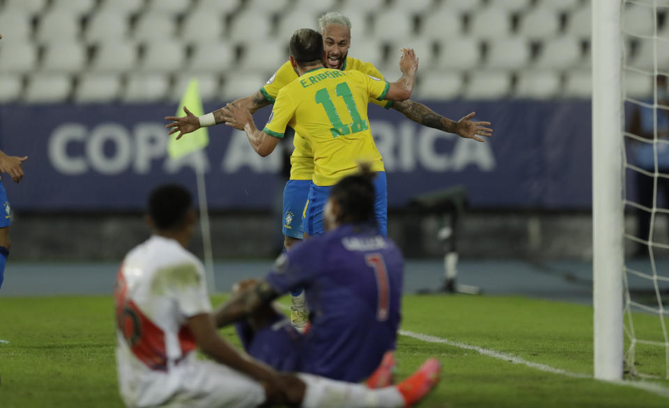 Brazil's Everton Ribeiro (11), celebrates with teammate Neymar after scoring his side's 3rd goal during a Copa America soccer match against Peru at Nilton Santos stadium in Rio de Janeiro, Brazil, Thursday, June 17, 2021. (AP Photo/Bruna Prado)