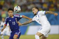 Japan's Yasuyuki Konno (L) and Greece's Konstantinos Mitroglou fight for the ball during their 2014 World Cup Group C soccer match at the Dunas arena in Natal June 19, 2014. REUTERS/Toru Hanai