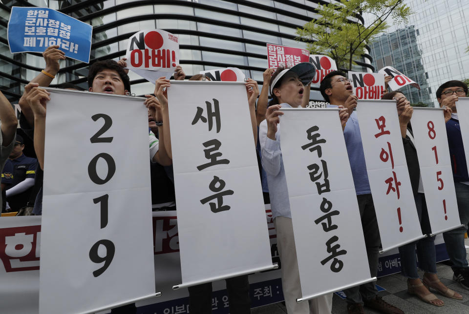 South Korean protesters hold signs during a rally denouncing the Japanese Prime Minister Shinzo Abe in front of the Japanese embassy in Seoul, South Korea, Thursday, Aug. 8, 2019. The letters read "Abolition of the General Security of Military Information Agreement, or GSOMIA, between South Korea and Japan." and "2019 New Independence Movement." (AP Photo/Lee Jin-man)