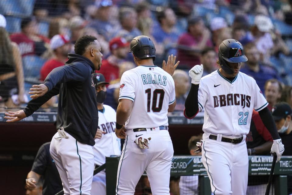 Arizona Diamondbacks' Josh Rojas (10) celebrates his run scored against the St. Louis Cardinals with Diamondbacks' Ketel Marte, left, and Josh Reddick (22) during the first inning of a baseball game Friday, May 28, 2021, in Phoenix. (AP Photo/Ross D. Franklin)