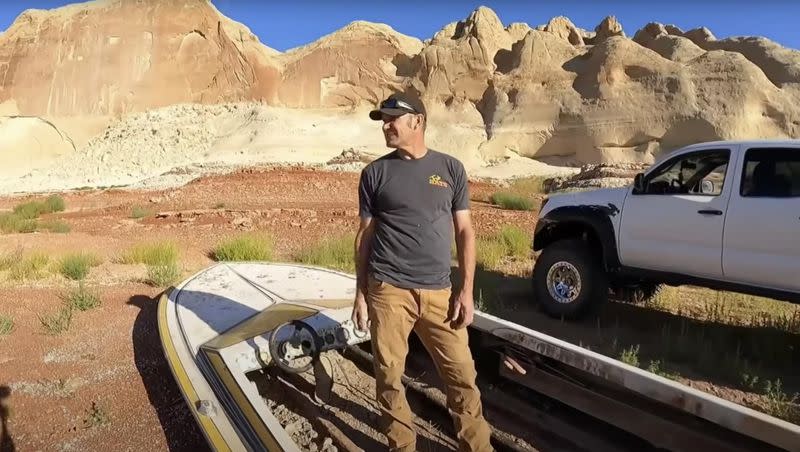 Paul Cox assesses a speedboat that has sunk in Lake Powell in 1993. His Fab Rats crew retrieved it after the lake levels had receded and restored the boat for its owners.