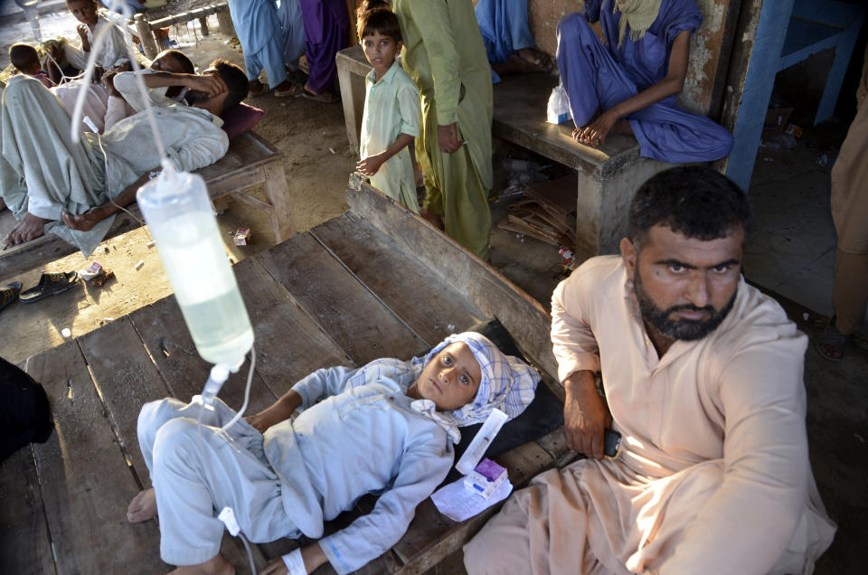 People receive treatment at a temporary medical center in Jaffarabad, a flood-hit district of Baluchistan province, Pakistan, Monday, Sept. 19, 2022. Pakistan said Monday there have been no fatalities for the past three days from the deadly floods that engulfed the country since mid-June, a hopeful sign that the nation is turning a corner on the disaster. (AP Photo/Zahid Hussain)
