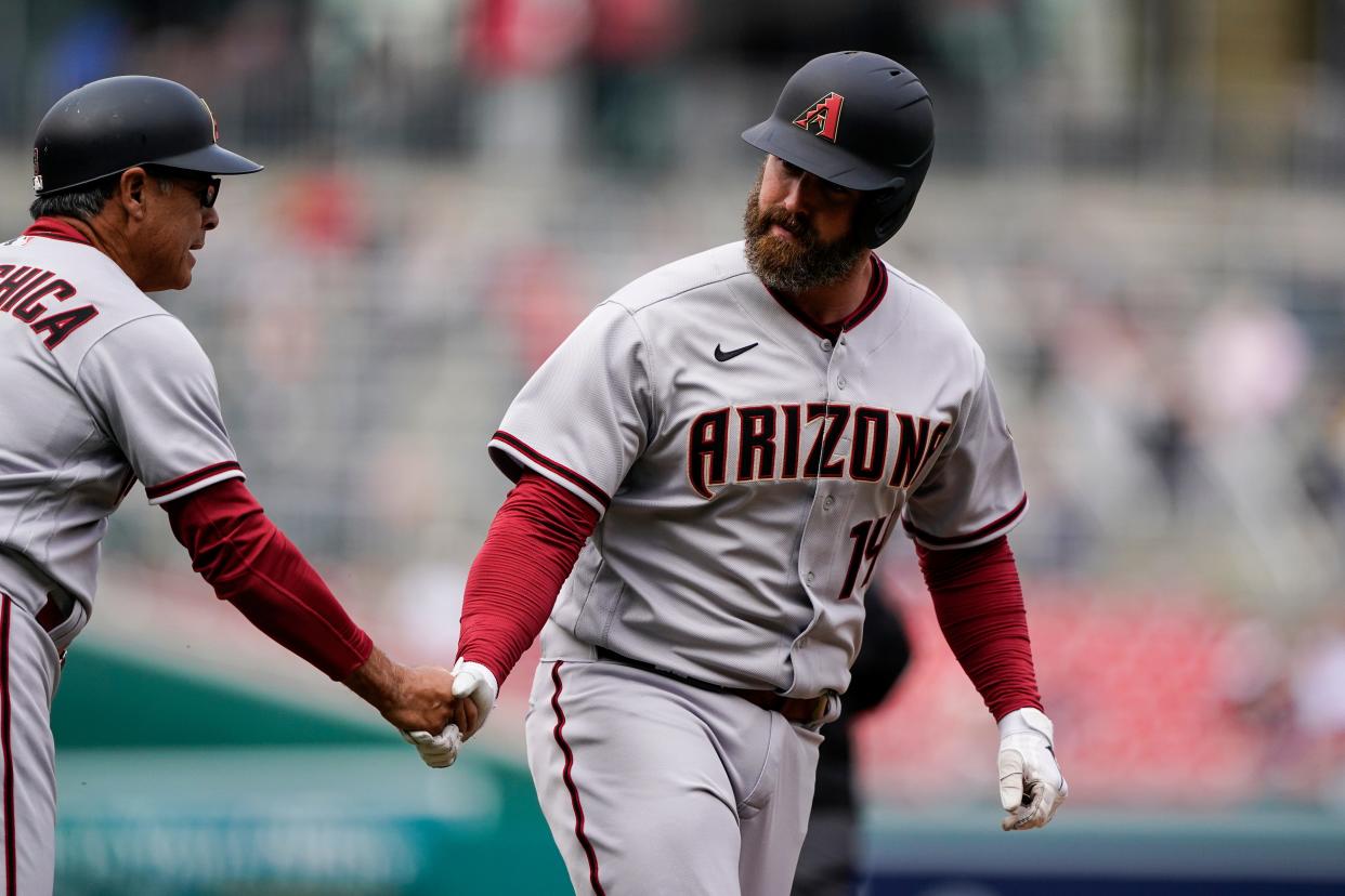 Arizona Diamondbacks' Matt Davidson, right, celebrates with third base coach Tony Perezchica as he runs the bases for his solo home run during the first inning of a baseball game against the Washington Nationals at Nationals Park, Thursday, April 21, 2022, in Washington.