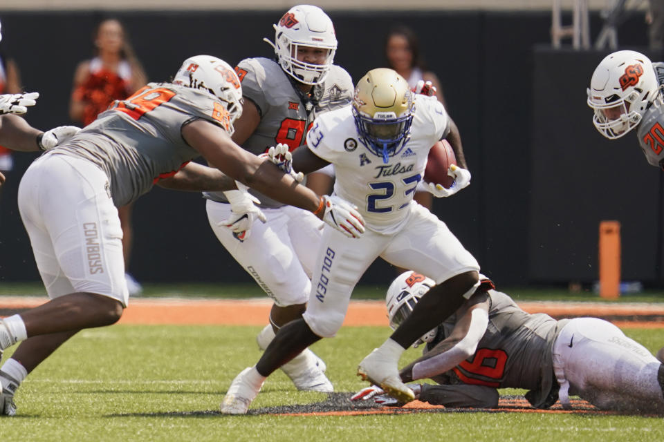 Tulsa running back Anthony Watkins (23) is defended by Oklahoma State defensive end Tyler Lacy (89) in the first half of an NCAA college football game, Saturday, Sept. 11, 2021, in Stillwater, Okla. (AP Photo/Sue Ogrocki)