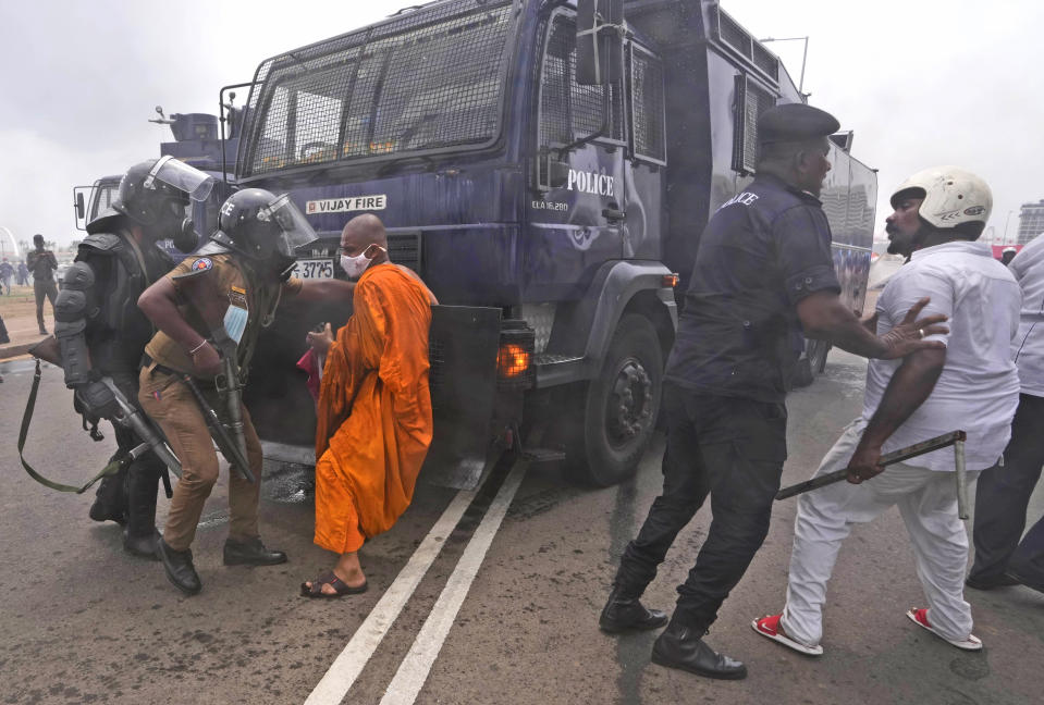 Supporters of Sri Lankan government attempt to block a police water canon truck during a clash with anti government protesters in Colombo, Sri Lanka, Monday, May 9, 2022. Government supporters on Monday attacked protesters who have been camped outside the office of Sri Lanka's prime minster, as trade unions began a "Week of Protests" demanding the government change and its president to step down over the country's worst economic crisis in memory. (AP Photo/Eranga Jayawardena)