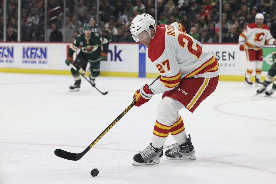 Calgary Flames left wing Nick Ritchie (27) handles the puck during the second period of the team's NHL hockey game against the Minnesota Wiled on Tuesday, March 7, 2023, in St. Paul, Minn. (AP Photo/Stacy Bengs)