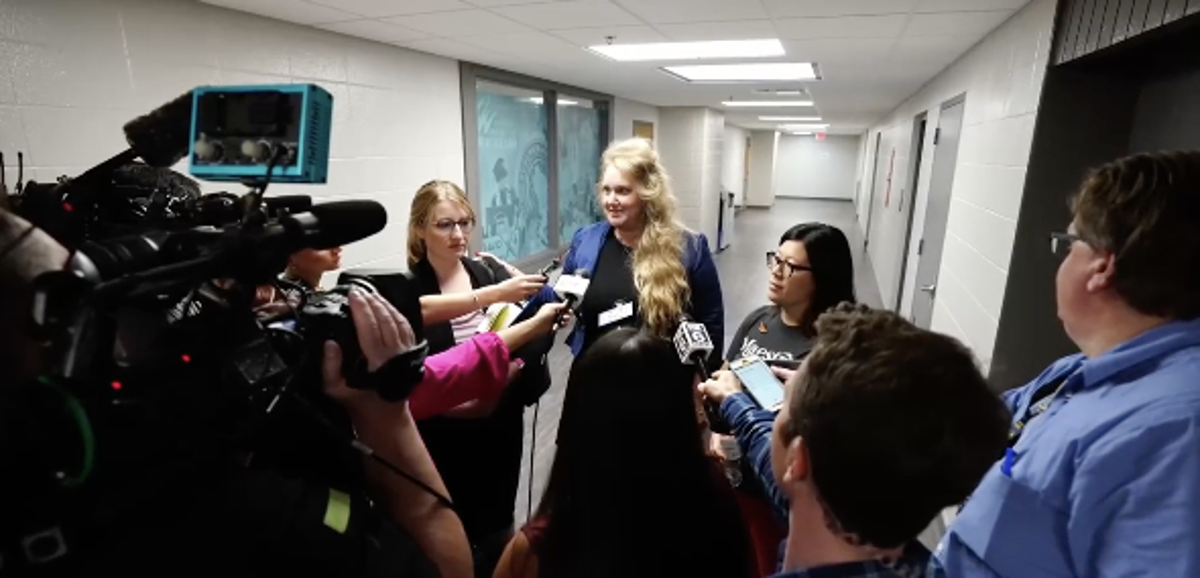 Wisconsin teacher Melissa Tempel and her attorney speak with reporters on 12 July, 2023, after the educator was fired for criticising a district decision not to let children sing a Miley Cyrus song about rainbows. (Milwaukee Journal-Sentinel broadcast screengrab)
