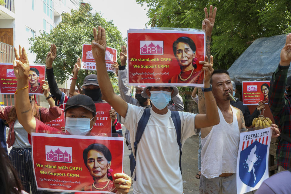 Anti-coup protesters flash the three-fingered symbol of resistance while holding slogans bearing pictures of deposed leader Aung San Suu Kyi during a demonstration in Yangon, Myanmar on Wednesday April 7, 2021. Threats of lethal violence and arrests of protesters have failed to suppress daily demonstrations across Myanmar demanding the military step down and reinstate the democratically elected government. (AP Photo)