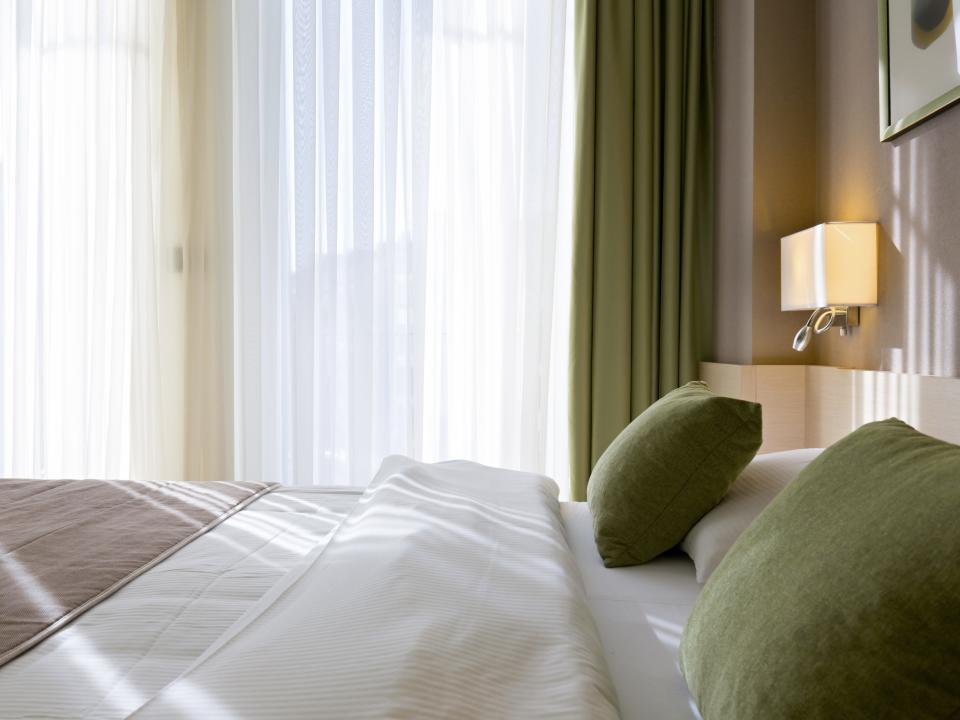 Bedroom with green and white bed spread and green and white curtains