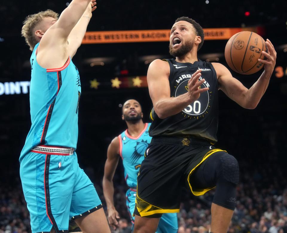 Nov 16, 2022; Phoenix, AZ, USA; Phoenix Suns center Jock Landale (11) defends a shot by Golden State Warriors guard Stephen Curry (30) at Footprint Center.