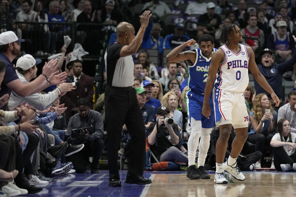 Dallas Mavericks guard Kyrie Irving, center rear, celebrates after sinking a three-point shot in front of Philadelphia 76ers' Tyrese Maxey (0) in the first half of an NBA basketball game, Thursday, March 2, 2023, in Dallas. (AP Photo/Tony Gutierrez)