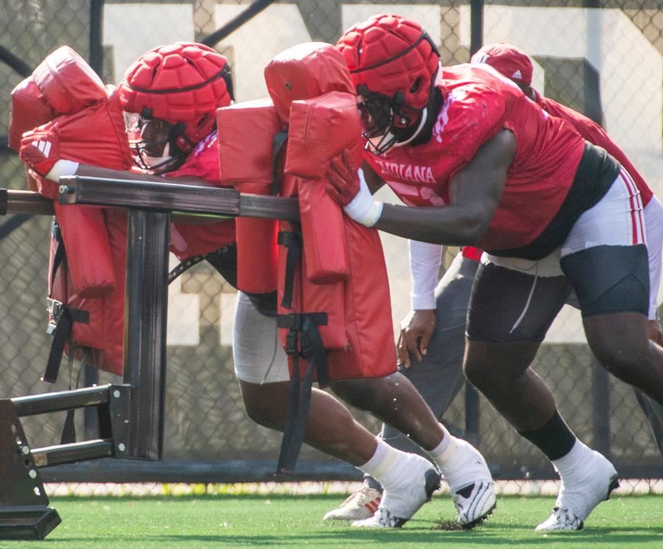 Indiana's Philip Blidi (96), left, along with Patrick Lucas Jr. (51) run a drill during fall camp for Indiana football at their practice facilities on Friday, Aug. 4, 2023.