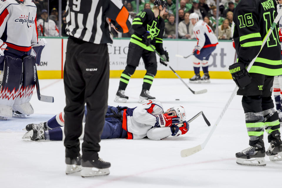 Washington Capitals defenseman Trevor van Riemsdyk (57) covers his face after being hit by a high stick during the first period of an NHL hockey game against the Dallas Stars, Saturday, Jan. 27, 2024, in Dallas. (AP Photo/Gareth Patterson)