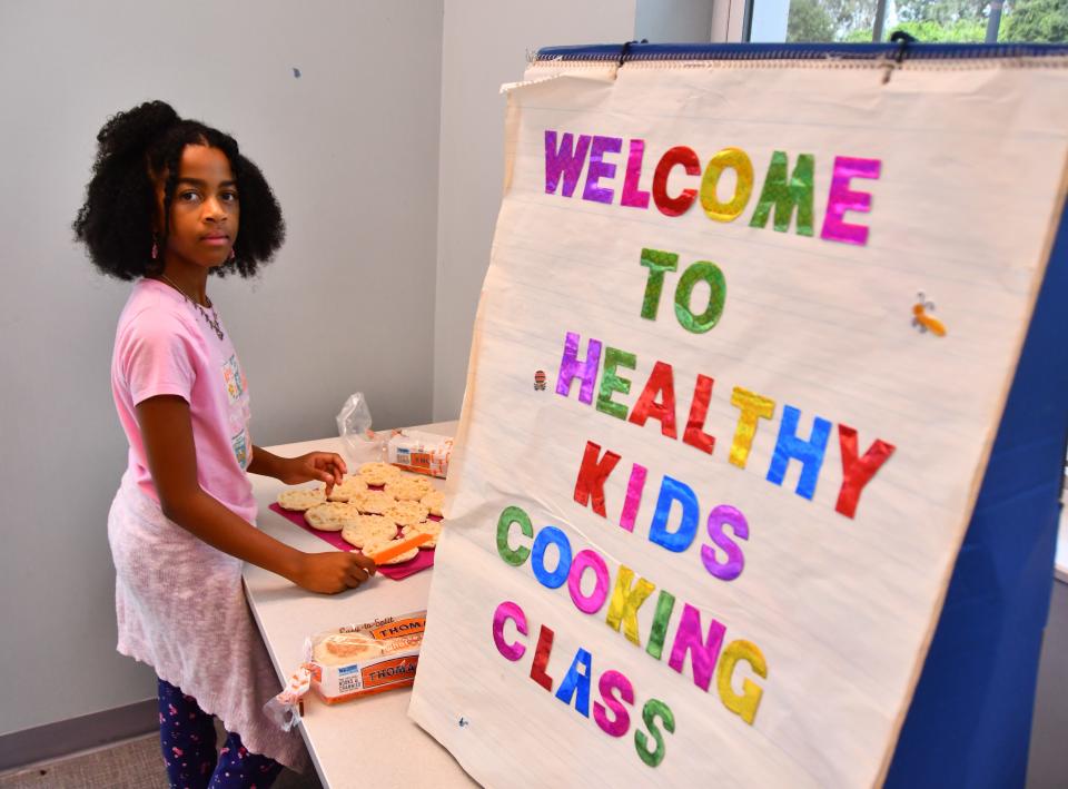 Children participate in the Cooking with Color cooking class at the Evans Community Center, making mini-pizzas on English muffins. The class was funded by the Space Coast Health Foundation.
