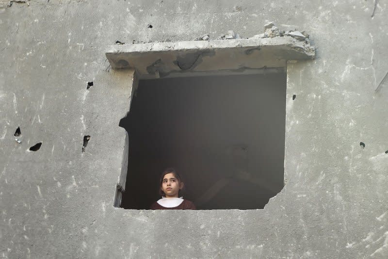 A Palestinian girl looks out the hole of a window of a building damaged by an Israeli strike in Rafah in southern Gaza Strip, Sunday, December. 24, 2023. UNRWA says it "cannot deliver meaningful aid" under intense Israeli bombardments of Gaza after the UN Security Council called for increased access. Photo by Ismael Mohamad/UPI