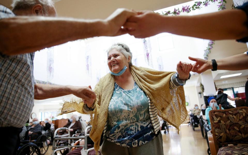 Residents and staff dance during an Easter concert for vaccinated residents at a nursing home in LA. he concert was the first social event held at the facility since the beginning of the pandemic amid newly eased restriction - Mario Tama/Getty Images