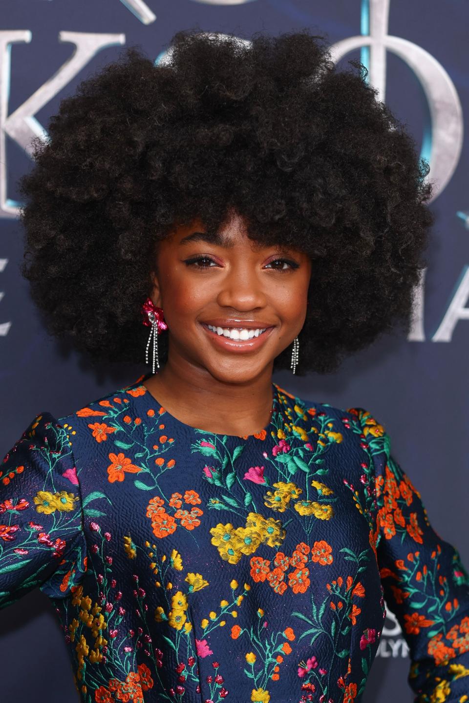 Leah in a floral dress smiling at a media event