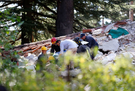 Rescuers work at a collapsed building following an earthquake in Amatrice, central Italy, August 24, 2016. REUTERS/Stefano Rellandini