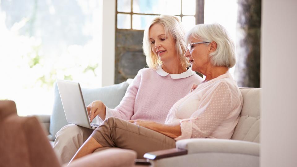 Daughter Helping Senior Mother With Computer At Home