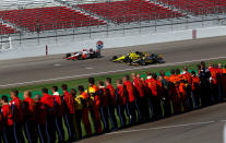 LAS VEGAS, NV - OCTOBER 16: Team members line the pitlane as the drivers complete five memorial laps to honor Dan Wheldon, driver of the #77 Dallara Honda, who died of injuries in a massive fifteen car crash during the Las Vegas Indy 300 part of the IZOD IndyCar World Championships presented by Honda at Las Vegas Motor Speedway on October 16, 2011 in Las Vegas, Nevada. (Photo by Tom Pennington/Getty Images)