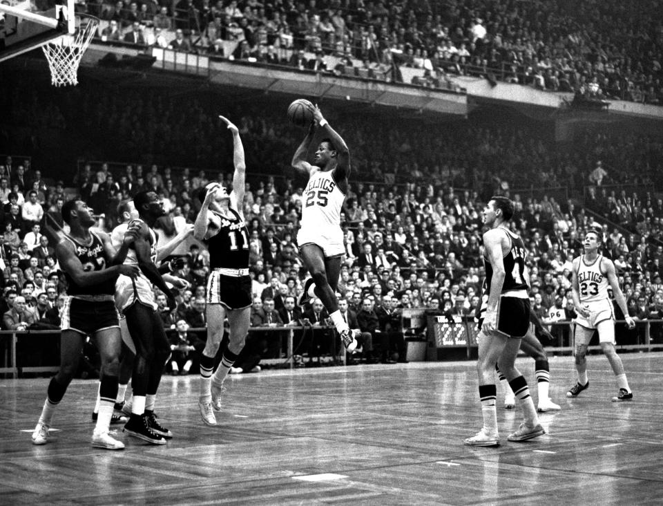 K.C. Jones looks to shoot as Frank Selvy of the Los Angeles Lakers goes for the block in a 1960s game.