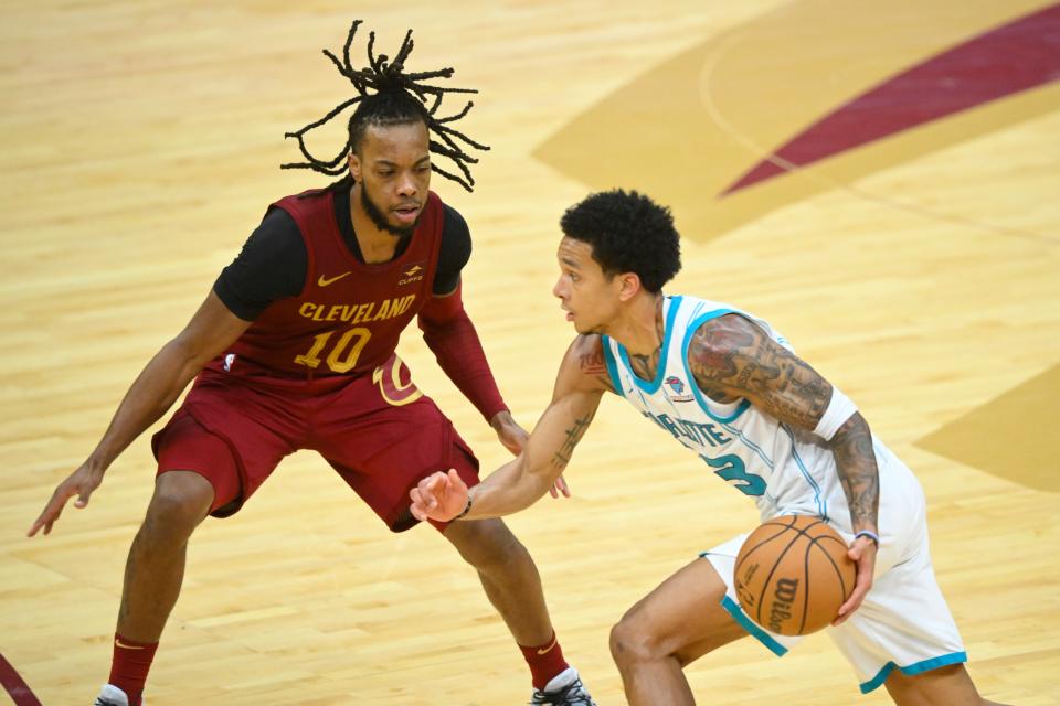 Cavaliers guard Darius Garland defends Charlotte Hornets guard Tre Mann in the fourth quarter, March 25, 2024, in Cleveland.