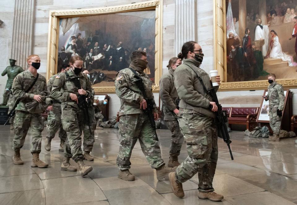 <p>Members of the National Guard walk through the Rotunda of the US Capitol in Washington, DC, January 13, 2021.</p>