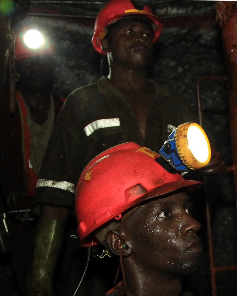 In this photo taken Thursday, Feb. 20, 2014, miners are photographed underground during a journalist's tour to the South Deep gold mine south of Johannesburg. Miners work some 2.4 kilometers (1.5 miles) underground in 12-hour shifts, where safety is a constant concern and everyone depends on everyone else to stick to precautions. (AP Photo/Themba Hadebe)