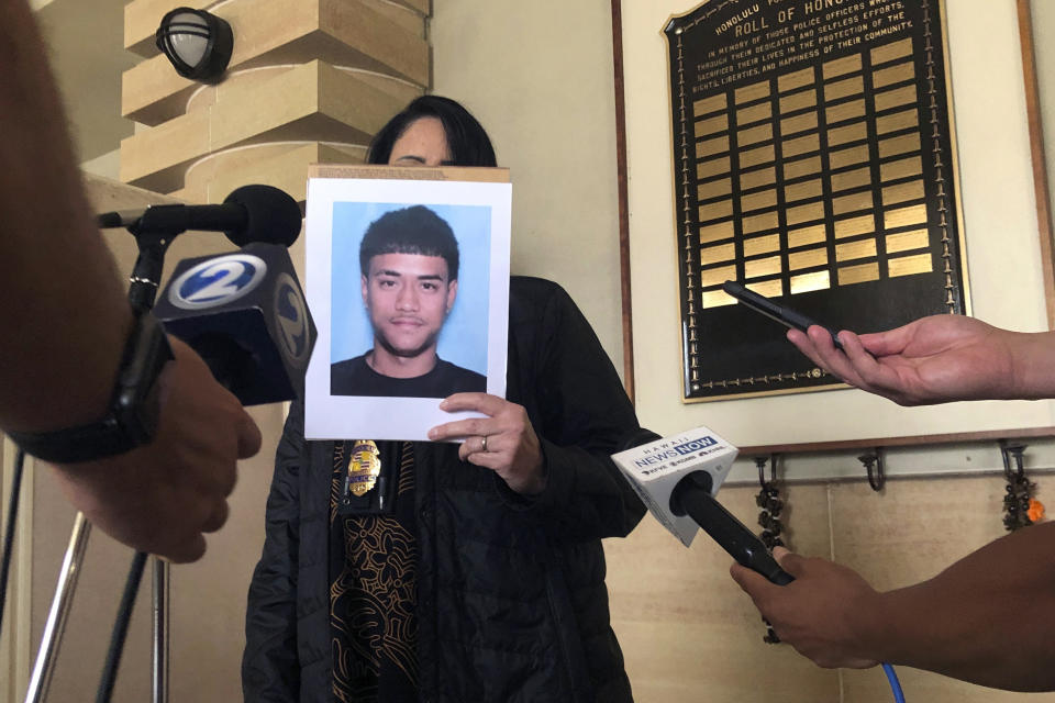 Lt. Deena Thoemmes, the lead homicide investigator for the Honolulu Police Department's Criminal Investigation Division, holds a photo of Jacob Borge, one of two suspects in a shooting Saturday, April 15, that killed two people and injured three others after a cockfight, during a news conference in Honolulu, Tuesday, April 18, 2023. Police in Hawaii have vowed to step up illegal gambling enforcement after one of the most serious shootings in state history called attention to the dangers that come with cockfighting, which has deep roots in the islands and remains popular despite being illegal. (AP Photo/Audrey McAvoy)