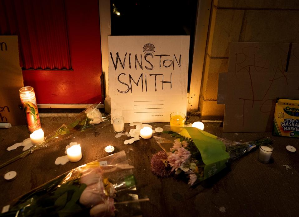 Candles and flowers are arranged at a vigil for Winston Boogie Smith Jr. early on Saturday, June 5, 2021. Authorities say Smith, wanted on a weapons violation, fired a gun from inside his vehicle before he was fatally shot by members of a federal task force as they were trying to arrest him.