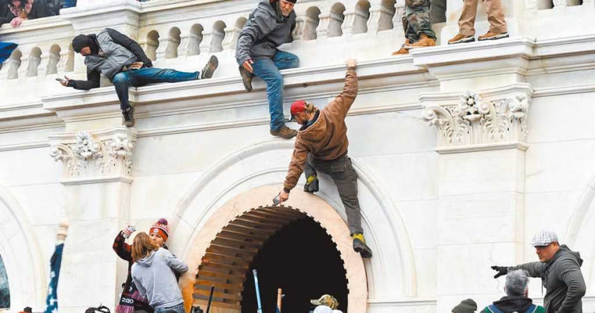 1月6日，美國時任總統川普的支持者爬上國會大廈牆壁抗議。（圖／路透）