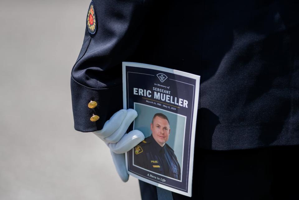 A member of the Ontario Provincial Police holds a program during the funeral of Ontario Provincial Police Sgt. Eric Mueller in Ottawa, on Thursday, May 18, 2023. Sgt. Mueller was killed in the line of duty while responding to call on May 11 in the village of Bourget, Ont. THE CANADIAN PRESS/Spencer Colby