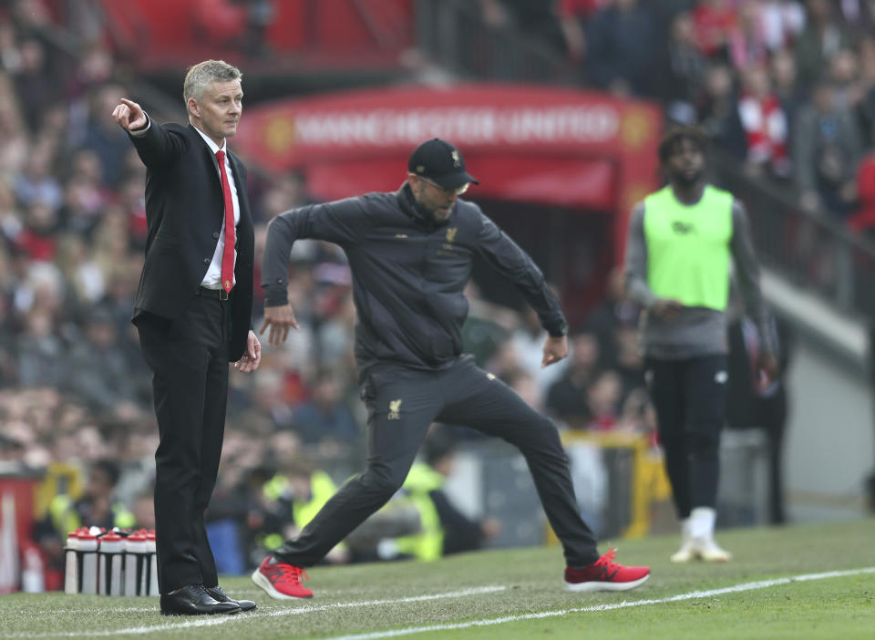 Manchester United manager Ole Gunnar Solskjaer, left, and Liverpool manager Juergen Klopp during the English Premier League soccer match between Manchester United and Liverpool at Old Trafford stadium in Manchester, England, Sunday, Feb. 24, 2019. (AP Photo/Jon Super)