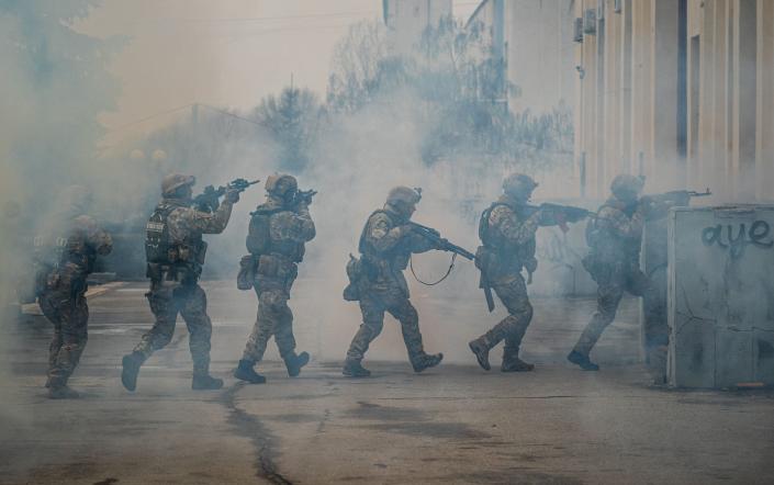 صفی از سربازان اوکراینی در حالی که در تمرین شرکت می کنند، از میان ابری از دود عبور می کنند، اسلحه هایشان بالا رفته است - دیمیتار دیلکوف / خبرگزاری فرانسه