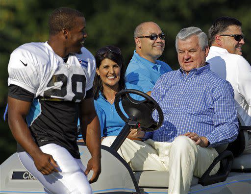 Carolina Panthers owner Jerry Richardson, front right, and South Carolina Gov. Nikki Haley, front left, greet running back Jonathan Stewart, left, during practice at the NFL team's football training camp in Spartanburg, S.C., Monday, July 30, 2012. (AP Photo/Chuck Burton)