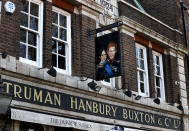 A sign depicting the image of Britain's Prince Harry and his wife Meghan, hangs outside the Duke of Sussex pub near Waterloo station, London, Tuesday March 9, 2021. Prince Harry and Meghan's explosive TV interview has divided people around the world, rocking an institution that is struggling to modernize with claims of racism and callousness toward a woman struggling with suicidal thoughts. (AP Photo/Frank Augstein)