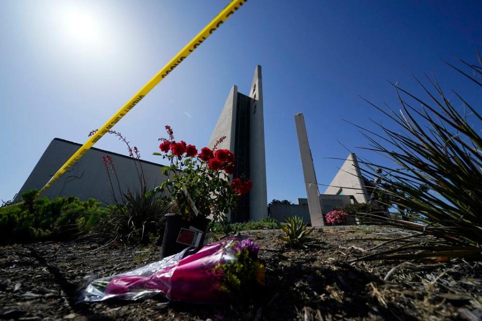 Flowers sit outside crime scene tape at Geneva Presbyterian Church on May 17, 2022, in Laguna Woods, Calif., where a shooting at the church on Sunday left one dead and five injured. Officials in California's Orange County are still trying to determine why a gunman opened fire in the church