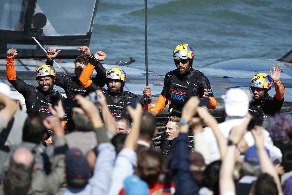 Members of Oracle Team USA wave to spectators after winning Race 18 of the 34th America's Cup yacht sailing race against Emirates Team New Zealand in San Francisco, California September 24, 2013. REUTERS/Stephen Lam (UNITED STATES - Tags: SPORT YACHTING)