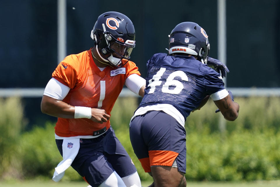 Chicago Bears quarterback Justin Fields, left, hands off the ball to running back Artavis Pierce during NFL football practice in Lake Forest, Ill., Wednesday, June 9, 2021. (AP Photo/Nam Y. Huh)