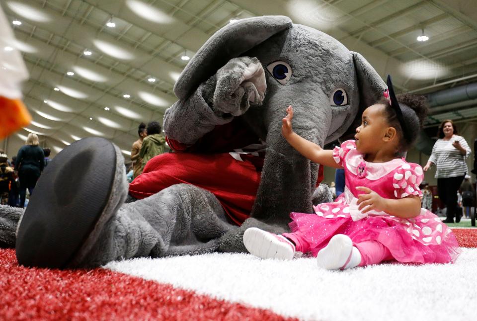 Big Al gives high five to Kayleigh Smith during the Halloween Extravaganza Monday, Oct. 28, 2019 in the Hank Crisp Indoor Practice Facility. [Staff Photo/Gary Cosby Jr.]