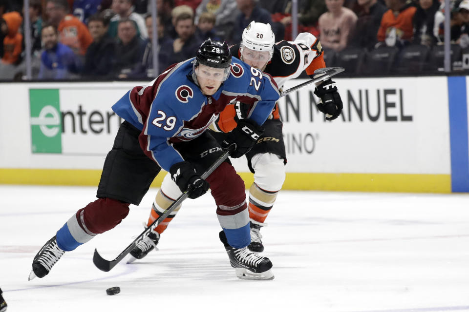 Colorado Avalanche's Nathan MacKinnon (29) is chased by Anaheim Ducks' Nicolas Deslauriers (20) during the first period of an NHL hockey game Friday, Feb. 21, 2020, in Anaheim, Calif. (AP Photo/Marcio Jose Sanchez)