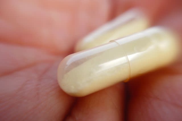 <p>lotusstock / Getty Images</p> Holding a capsule in the hand