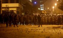 Stones are seen on the ground as Lebanese police gather during a protest against the newly formed government in Beirut