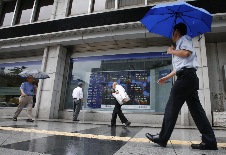 People walk by an electronic stock indicator in Tokyo Monday, Aug. 6, 2012. Asian stock markets rose sharply in early trading Monday, boosted by stronger-than-expected U.S. hiring figures for July following three months of weak job gains. (AP Photo/Shizuo Kambayashi)