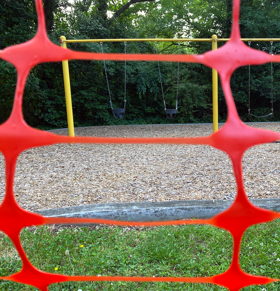 A swingset in Lyon Park is behind orange snow fence because of lead contamination