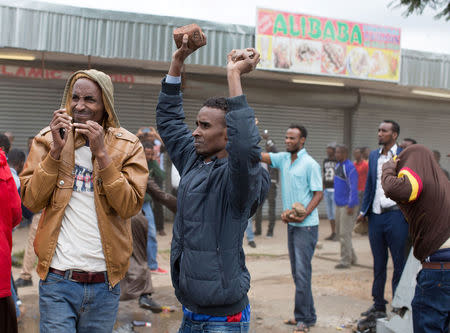 Somali immigrants hold rocks during clashes in Pretoria, South Africa, February 24, 2017. Police fired tear gas, water cannon and rubber bullets to disperse rival marches by hundreds of protesters in Pretoria on Friday, after mobs looted stores this week believed to belong to immigrants. REUTERS/ James Oatway.