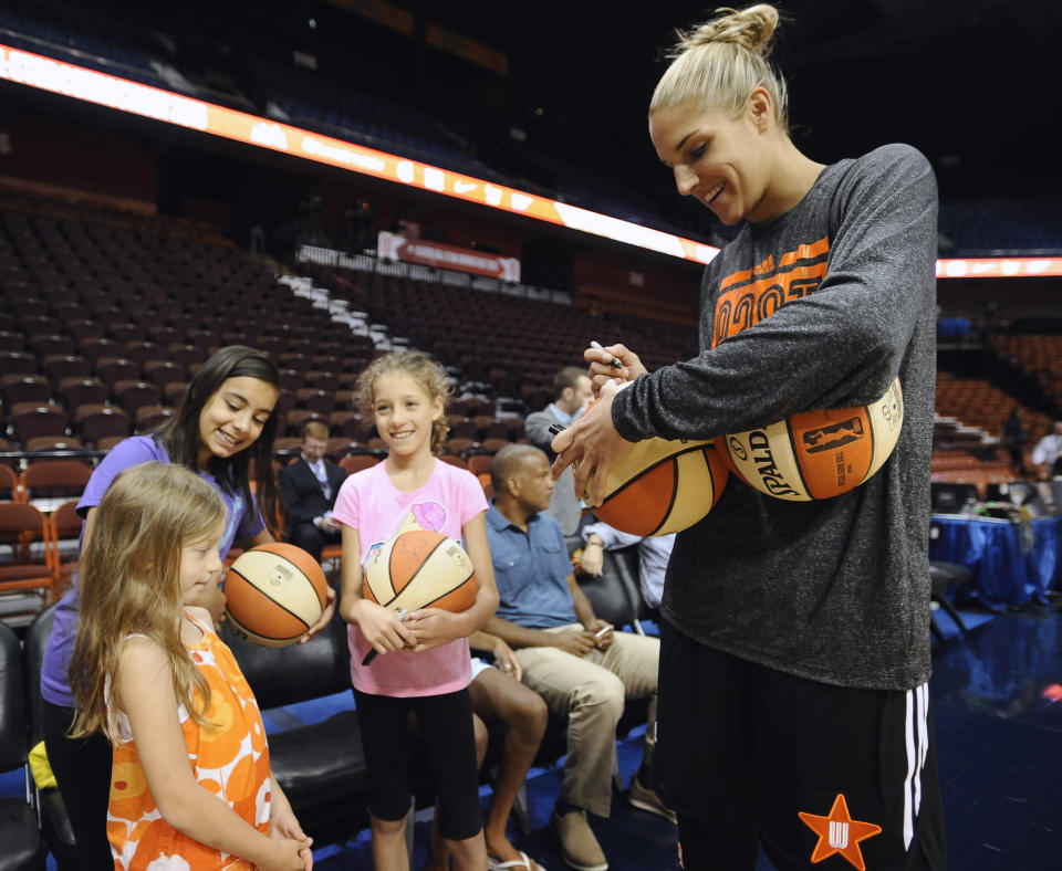 East’s Elena Delle Donne, of the Chicago Sky, right, signs autographs for young fans before the WNBA All-Star basketball game against the West, Saturday, July 25, 2015, in Uncasville, Conn. (AP Photo/Jessica Hill)