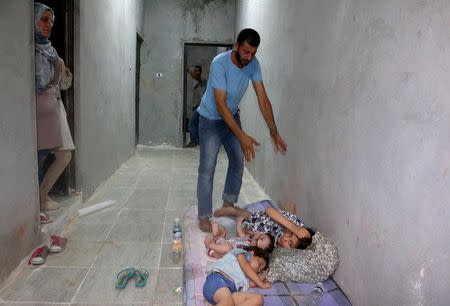 Surviving migrants are seen at a detention center after their boat sank off the coastal town of Zuwara, west of Tripoli, August 27, 2015. REUTERS/Hani Amara