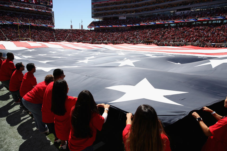 Volunteers hold up a giant flag at a Lions-49ers game in Santa Clara, Calif.  (Ezra Shaw/Getty Images)