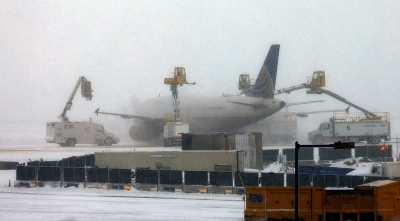 A United jet is de-iced prior to takeoff after a snowstorm at Denver International Airport